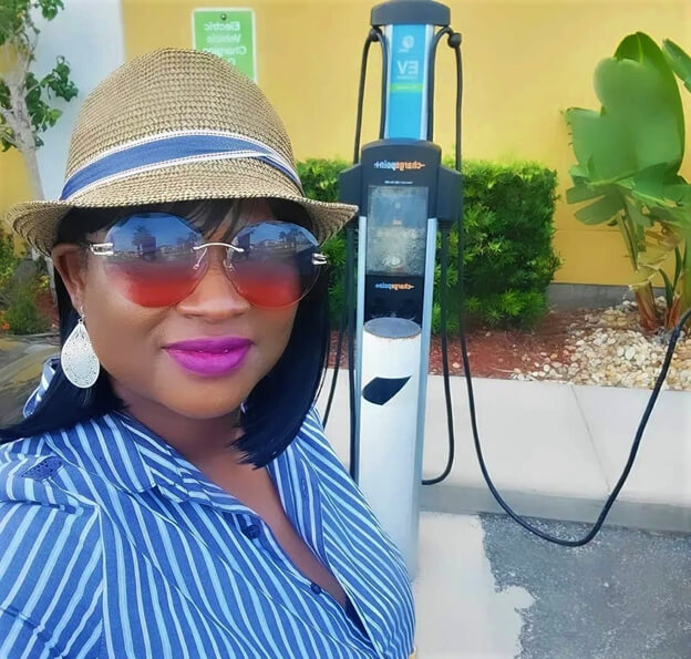 Selfie of a woman at an electric vehicle charging station